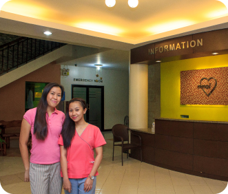 Two ladies in front of MMCI front desk 